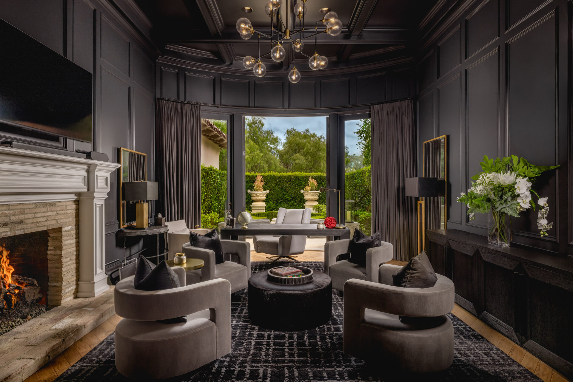 The den shifts into a darker setting with charcoal paneled walls running across the ceiling and wrapping the room.