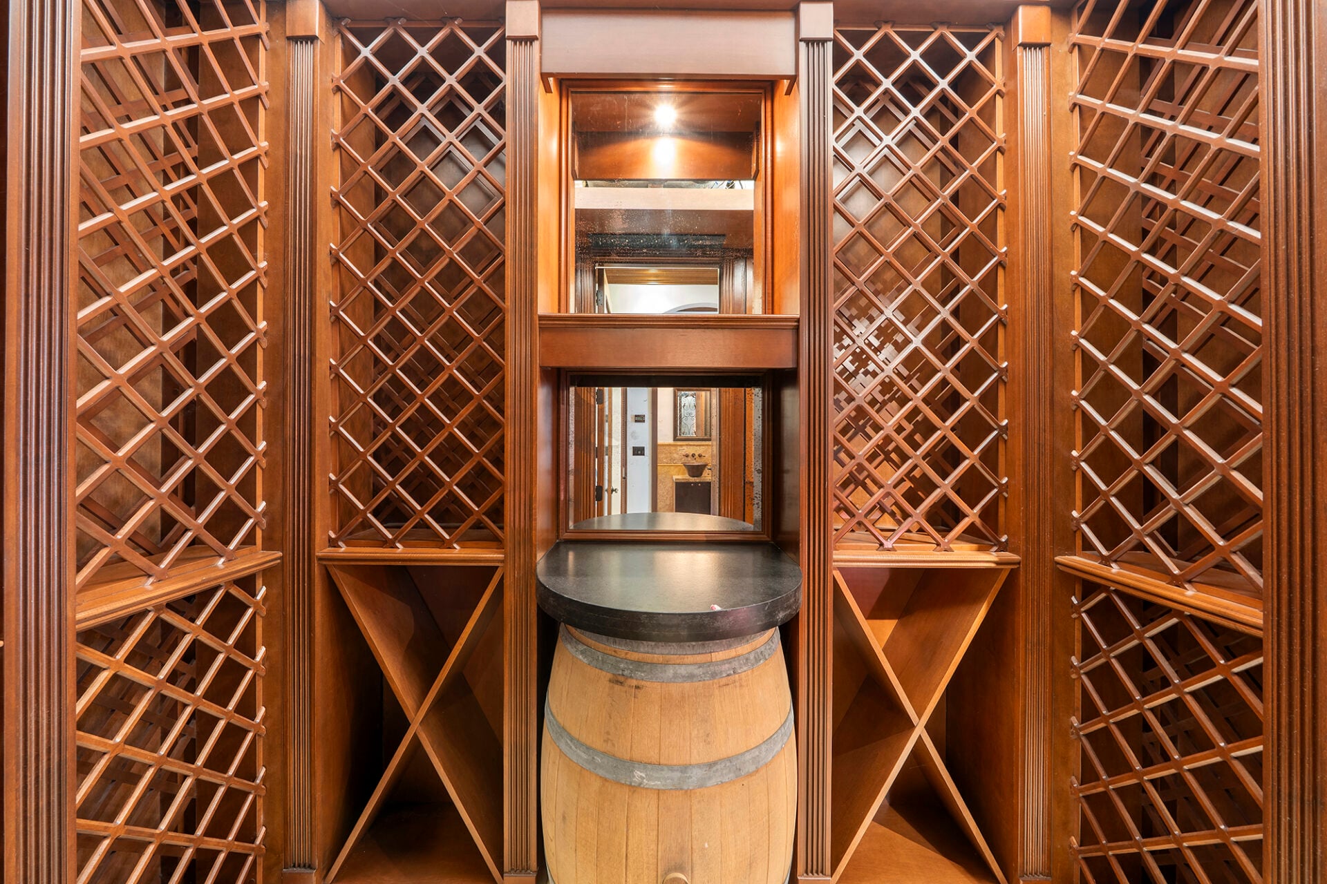 A climate-controlled 500-bottle wine cellar, finished in rich wood cabinetry with floor-to-ceiling lattice racks wrapping every wall.