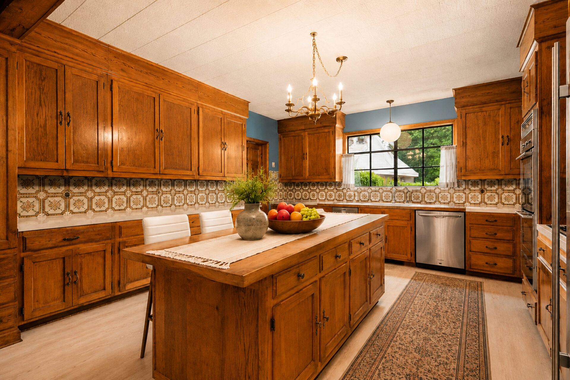 Kitchen with patterned tile backsplash, stainless steel appliances, generous counter space, and a wide picture window overlooking the greenery outside,