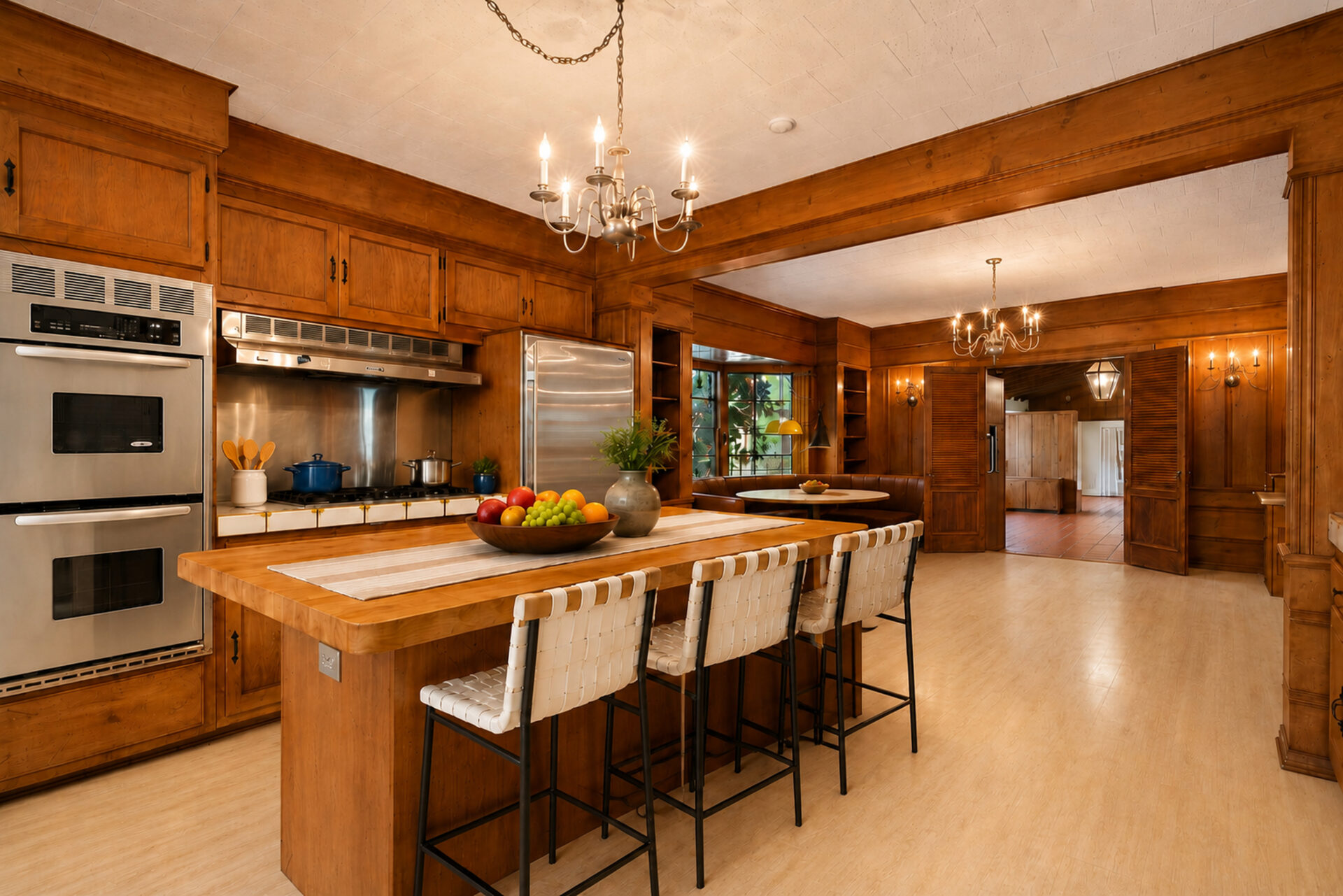 An expansive kitchen wrapped in rich wood cabinetry that surrounds a large center island. 