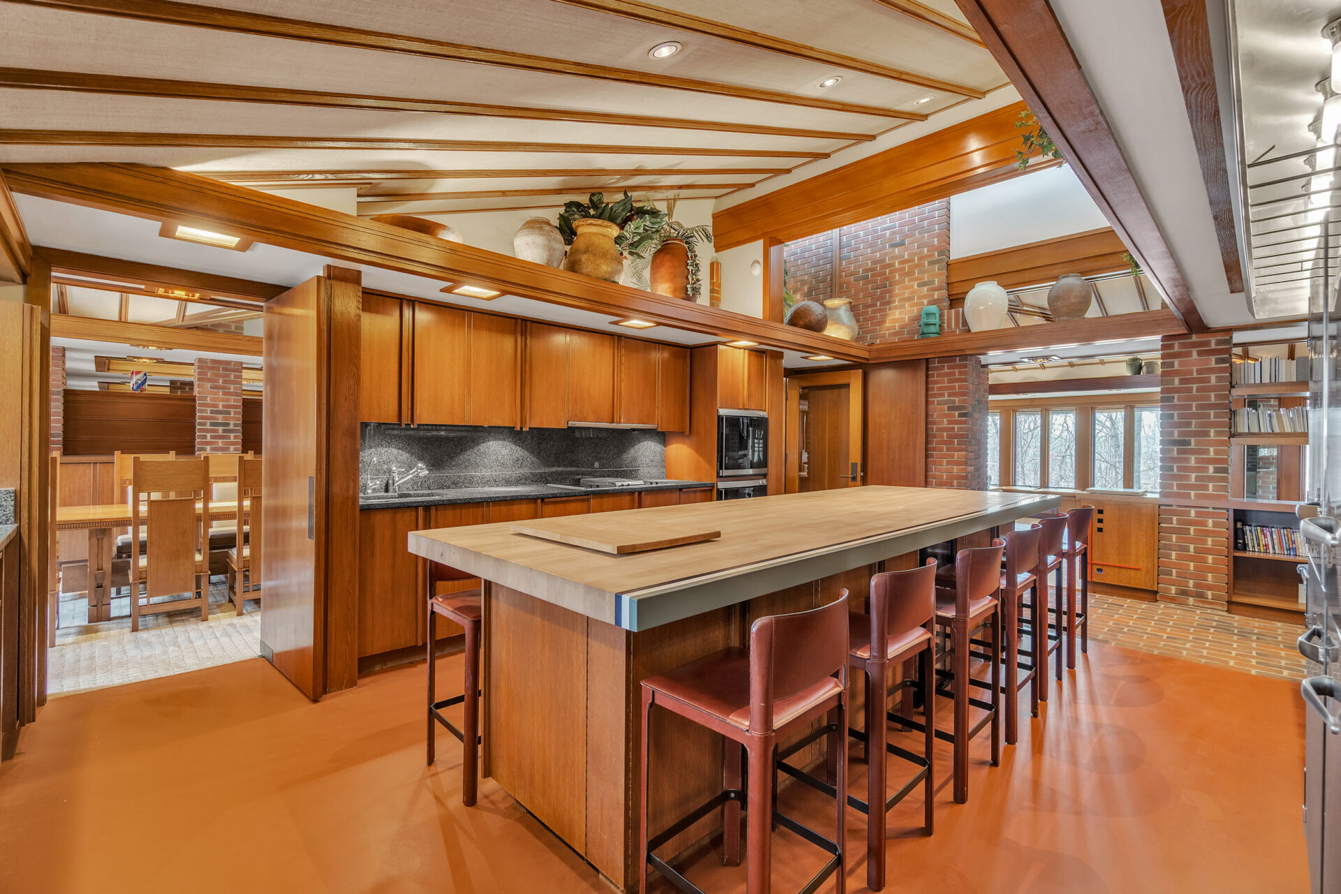 On the other side of the fireplace, the kitchen combines commercial-grade functionality with warm wood finishes.