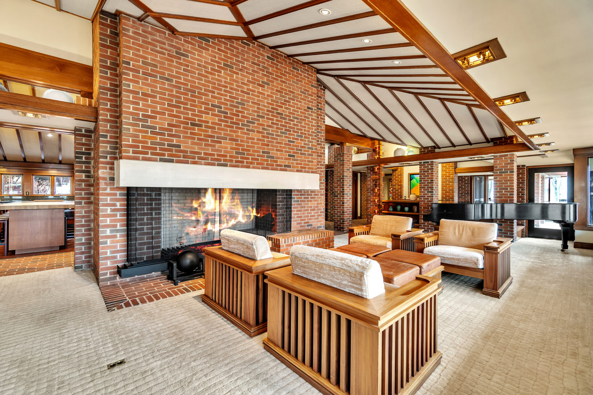 The main house's family room sits against a double-sided brick fireplace that rises to the ceiling, dividing the expansive room while keeping each seating area connected.