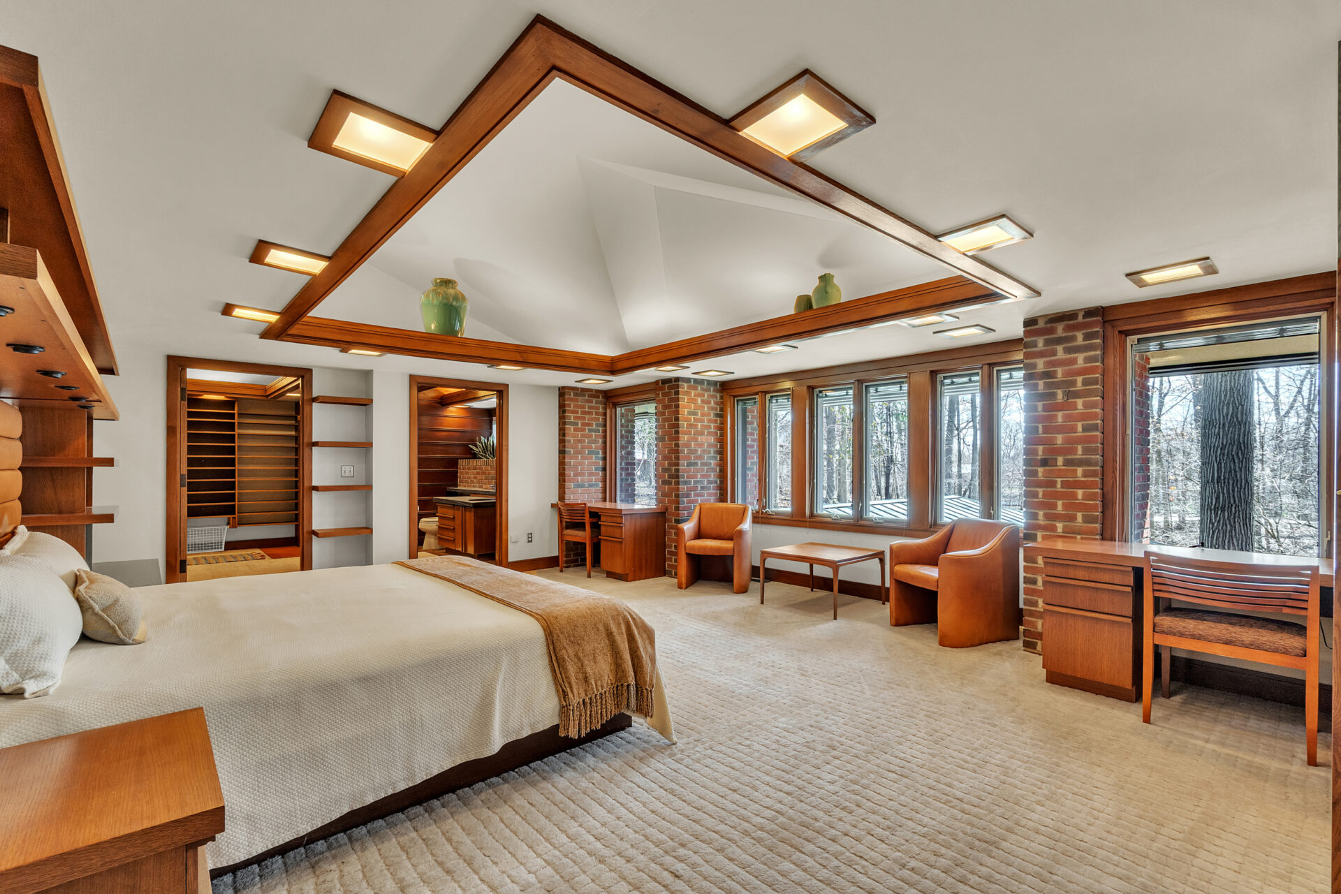 Built-in desks, a sitting area, and custom wood detailing continue the home's unique design, while a large skylight overhead fills the room with sunlight.