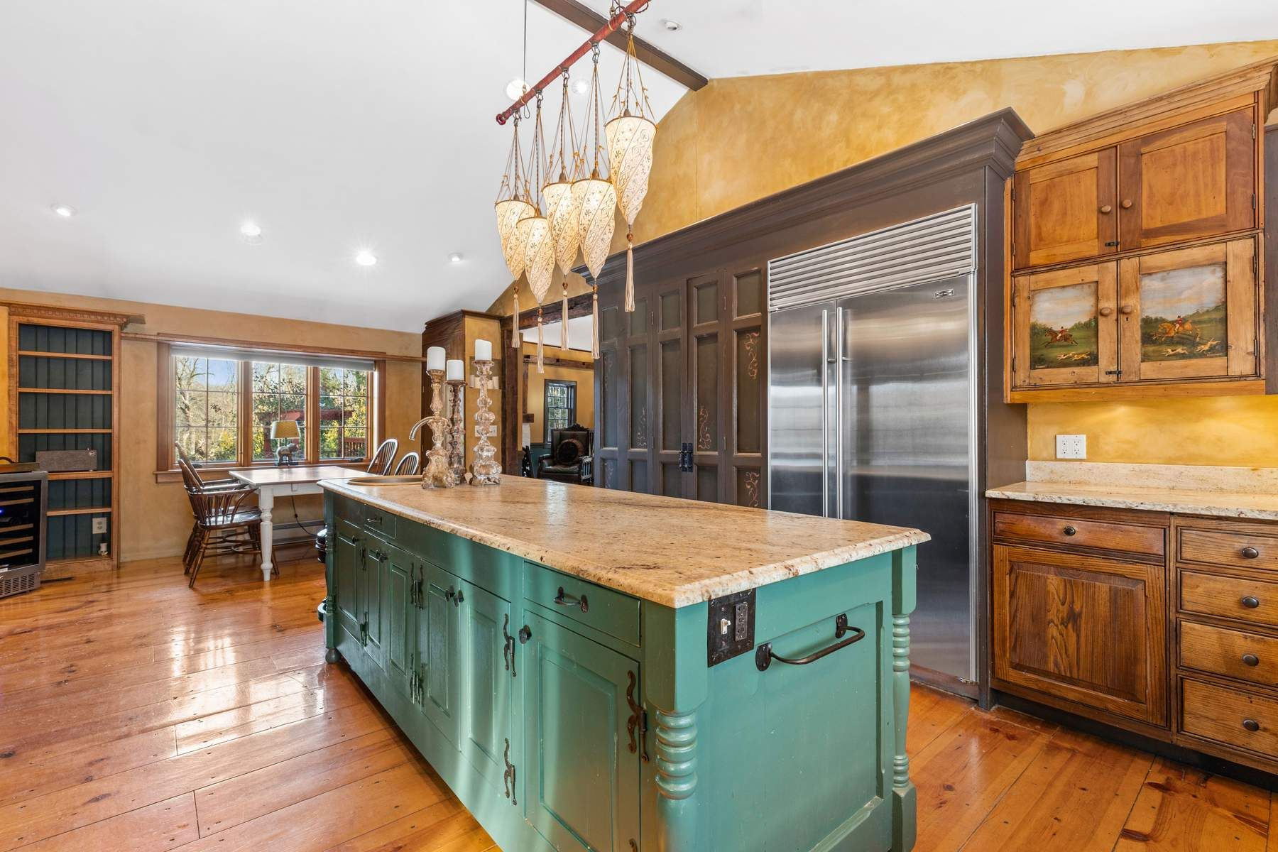 On the opposite side, the island overlooks a casual dining nook framed by large windows.