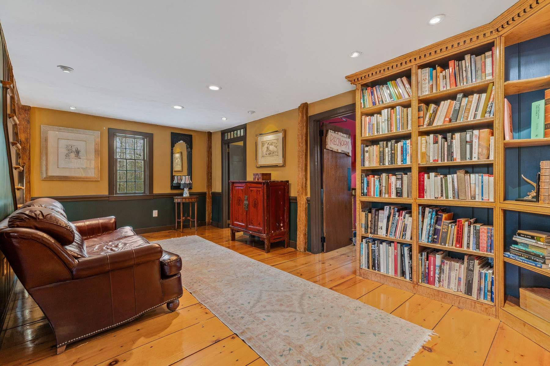 Floor-to-ceiling bookshelves line the wall to create a comfortable reading nook.