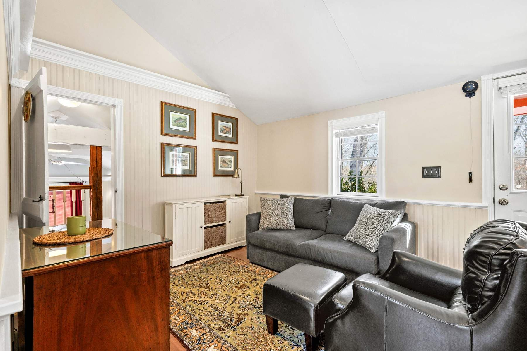 A cozy sitting area with a sofa and armchair tucked beside the windows.