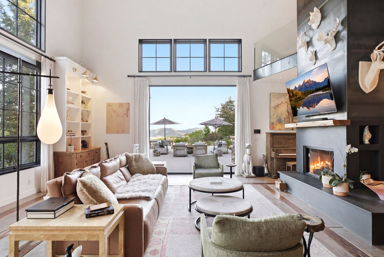 A wall of floor-to-ceiling windows and retractable glass doors draws your eye straight through to the patio.