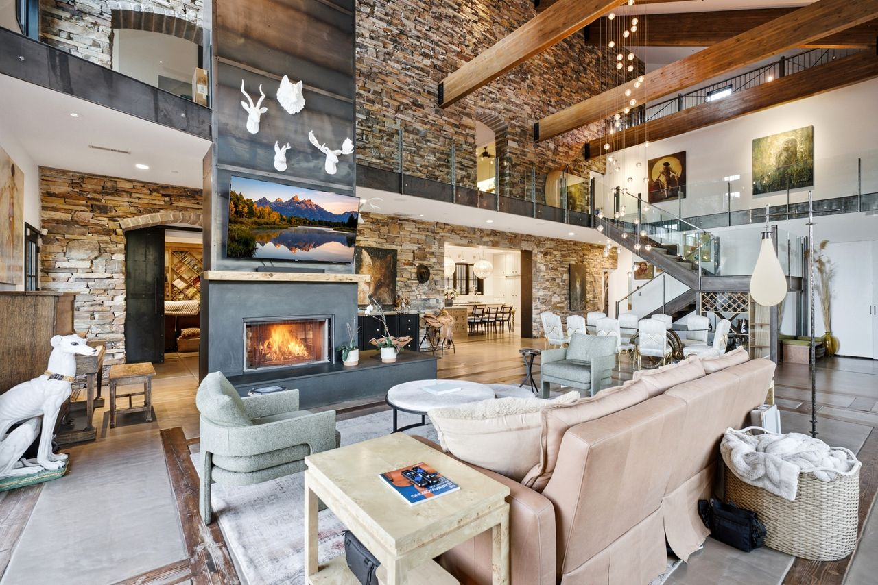 A soaring great room with a steel fireplace that rises nearly 30 feet to the exposed timber ceiling. 