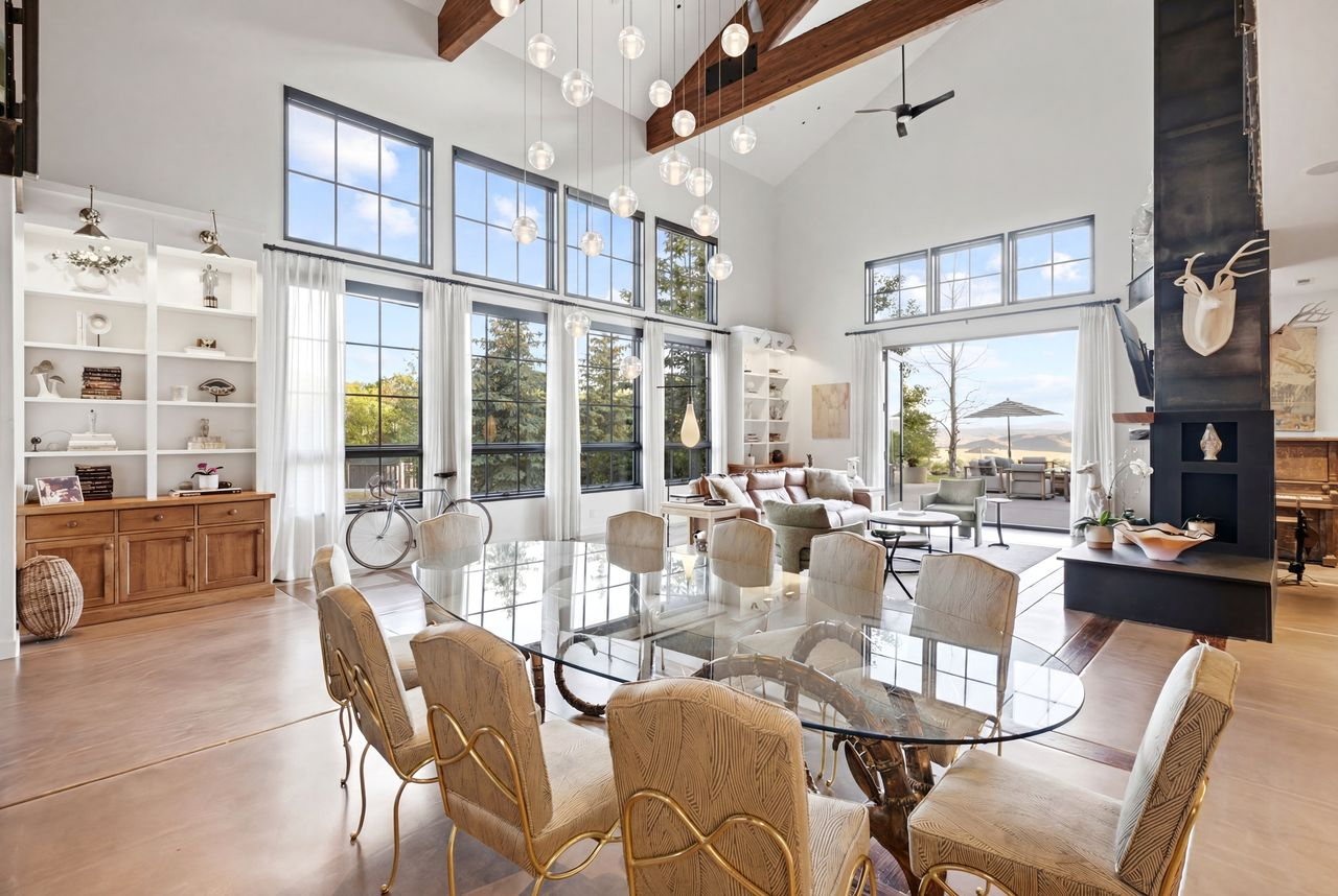 The dining area sits beneath a cascading cluster of glass pendant lights.