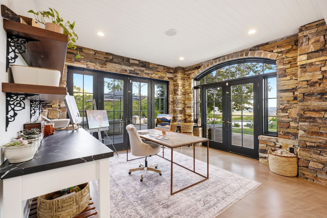 The workspace has a built-in work counter that lines one wall, while the desk is positioned to face the outdoor scenery.