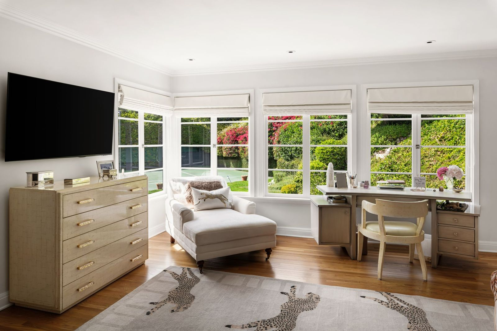 A wall of windows fills the room with light and overlooks the tennis court.