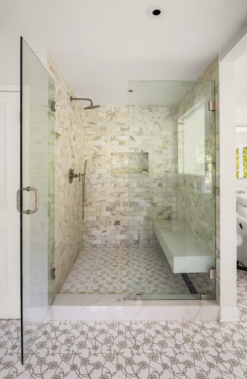 Wrapped in marble tile and complete with a built-in bench, the shower has plenty of space.