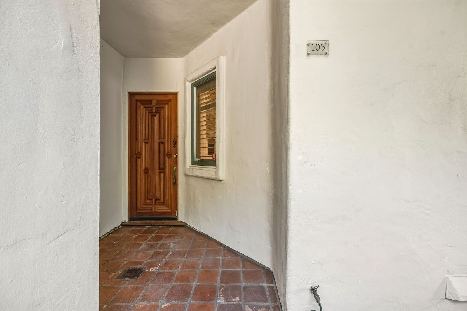 A recessed alcove and richly detailed carved front door provide a welcoming entrance to the home.
