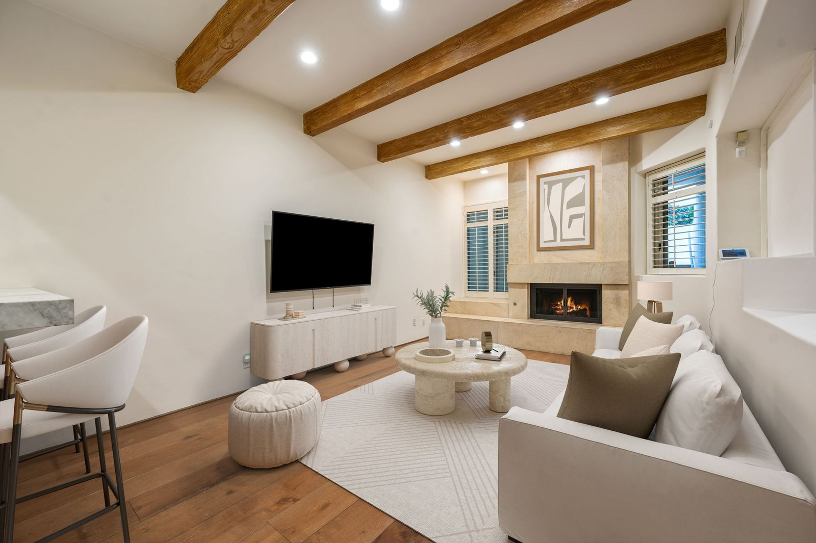 The home opens directly into a warm and inviting living room with a floor-to-ceiling limestone fireplace. 