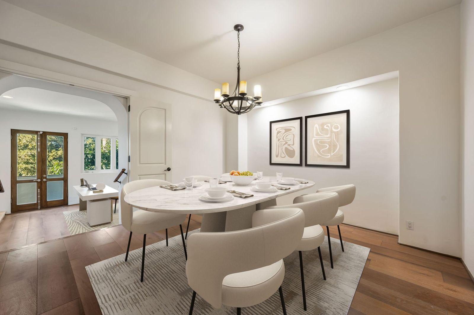 The dining room offers a more formal setting for meals beneath a wrought-iron chandelier.