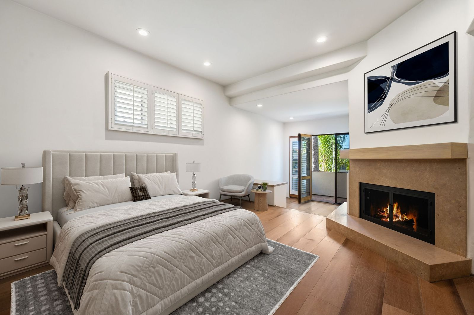 The suite's bedroom features a corner fireplace framed in stone, creating a warm focal point opposite the bed.