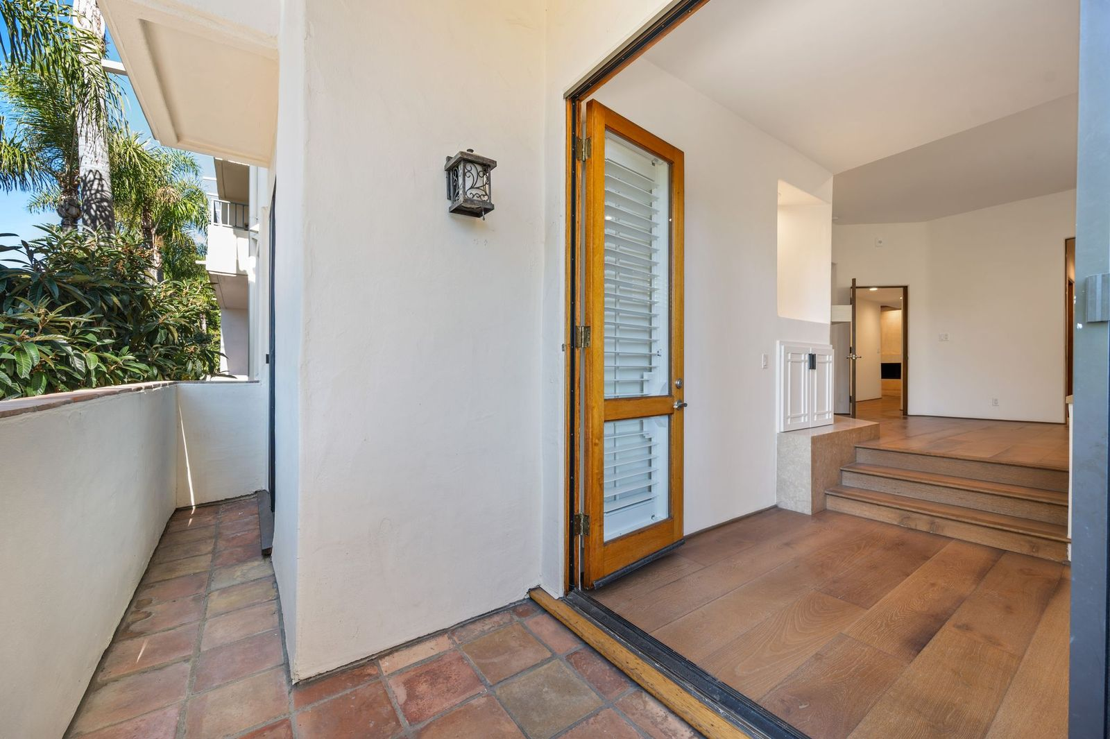 A few steps below, the suite opens into a private sitting area with French doors leading to a secluded terrace.