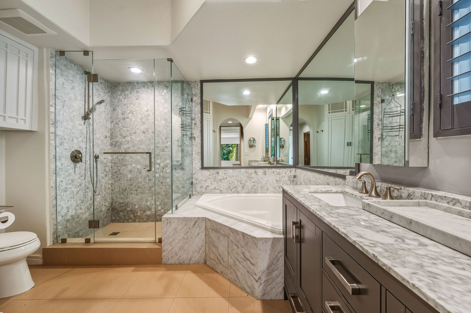 Alongside a deep soaking tub, the oversized glass-enclosed shower creates a functional layout designed for everyday comfort.