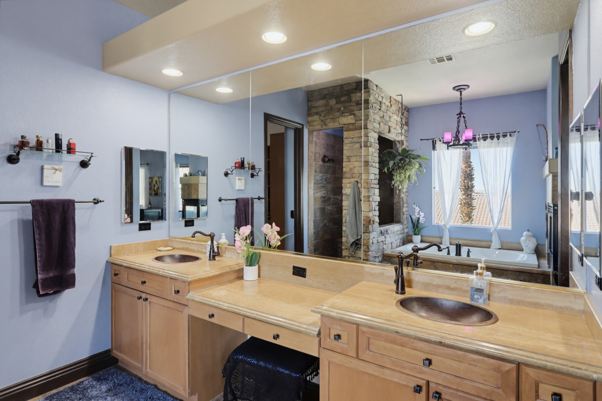 A light-wood dual-sink vanity beneath a full wall mirror. 