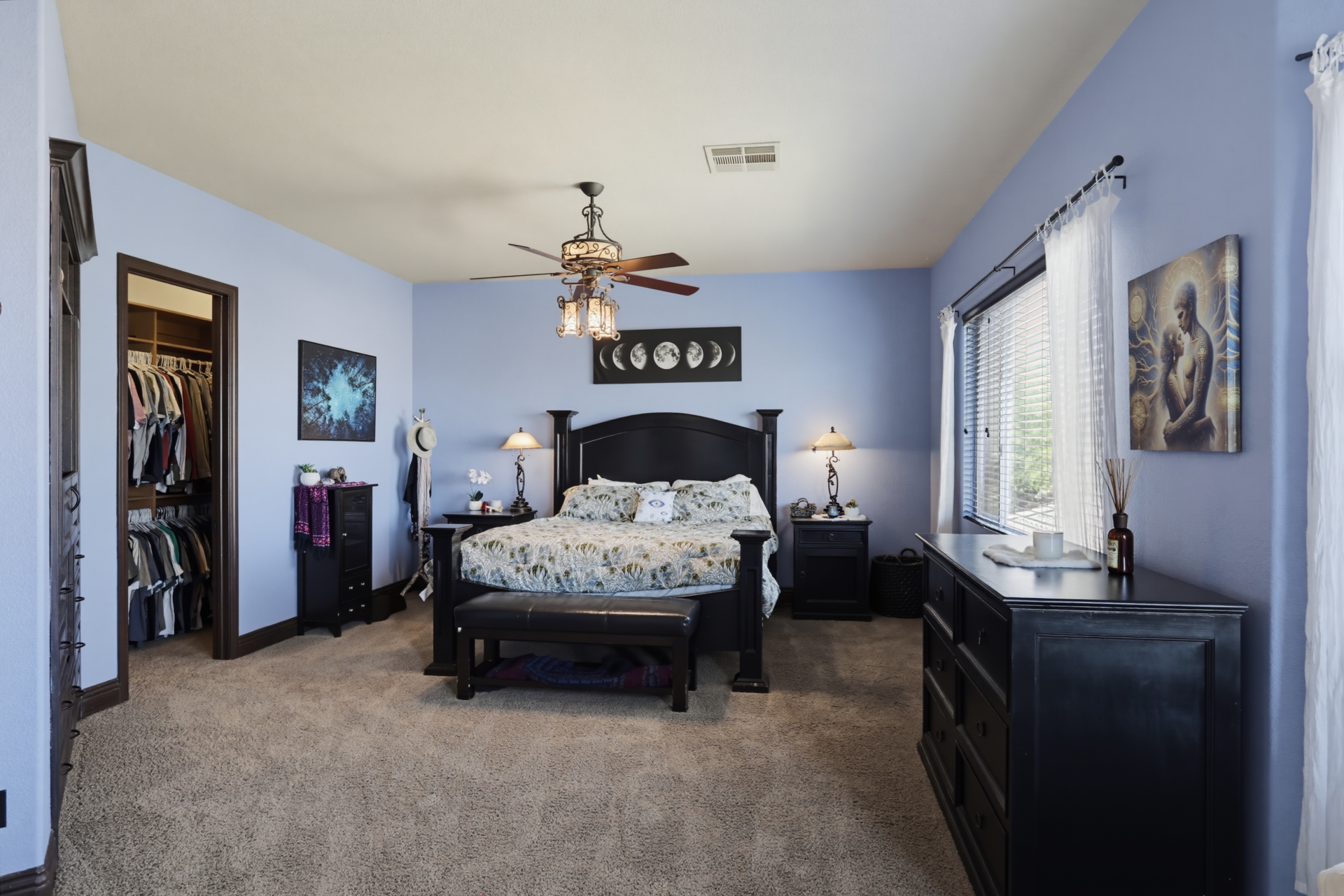 The purple-painted bedroom begins the suite with a bed placed next to one of the suite's walk-in closets.