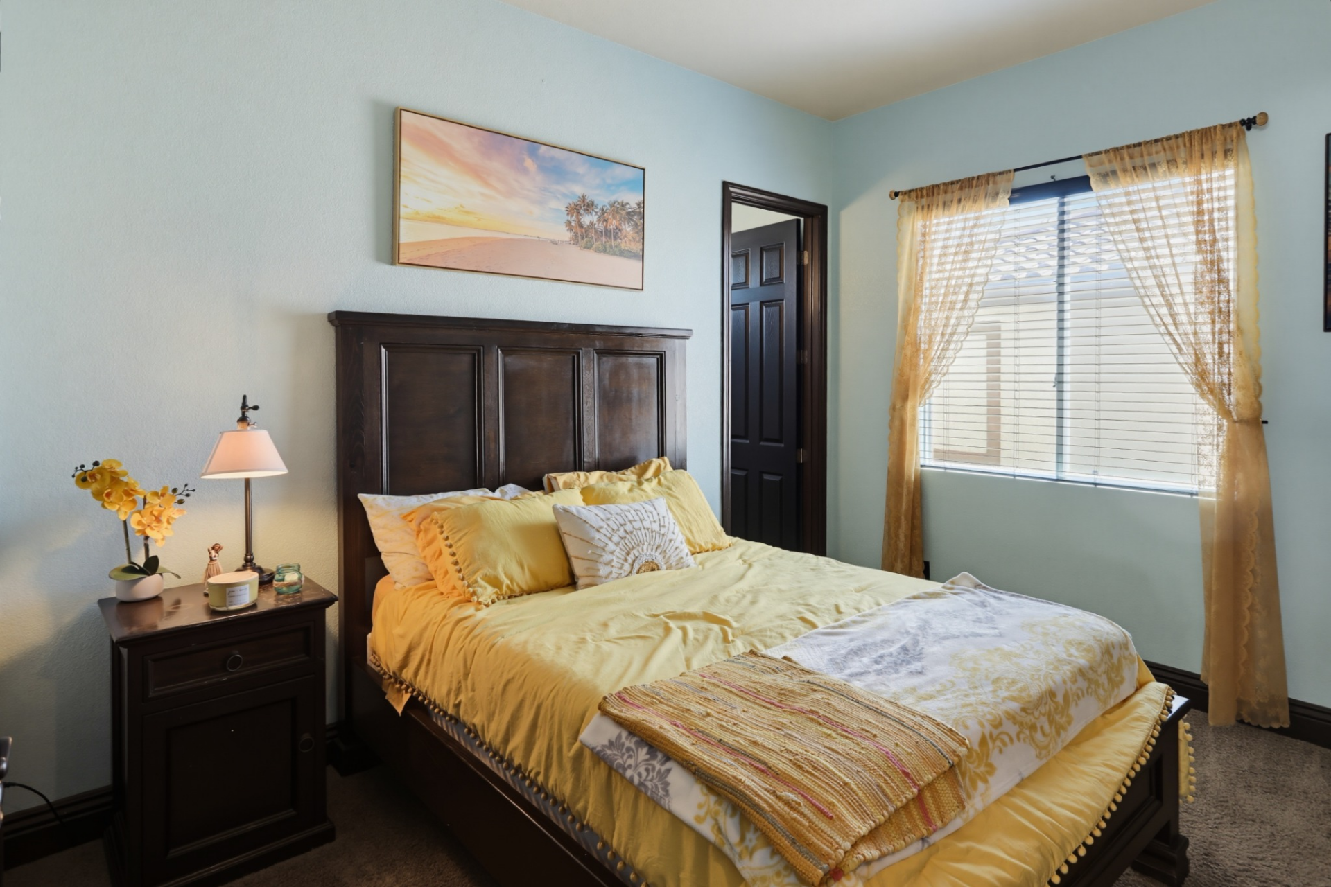 The second upstairs bedroom has a brighter color palette with light blue walls and coordinating yellow accents throughout the furnishings. 