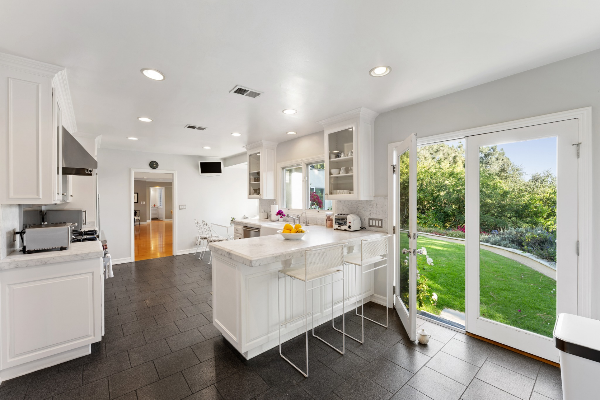 A central island adds additional prep space while also serving as a casual bar-top next to French doors that open to the backyard.