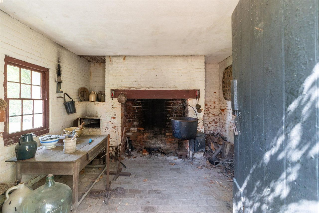 Entering through the original doorway reveals a remarkably preserved cooking space centered around a massive open hearth.