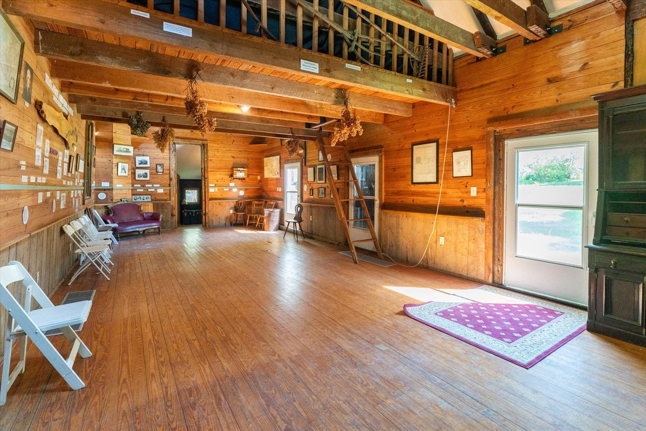 Exposed timber framing stretches across the open hall, where exhibits, maps, photographs, and artifacts document the property's long history.