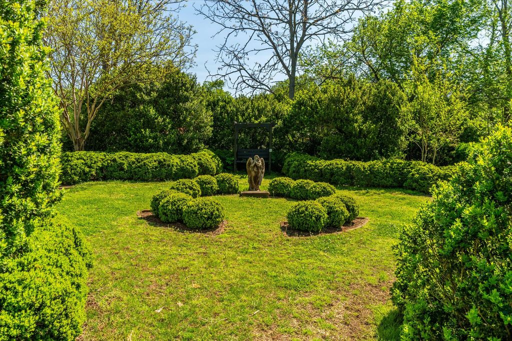 A peaceful garden surrounded by hedges and trees to make it feel more private.