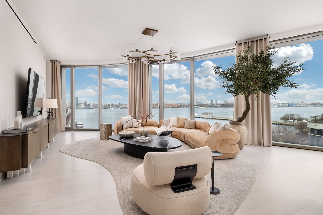 Great room lined with glass walls looking out to Hudson River.