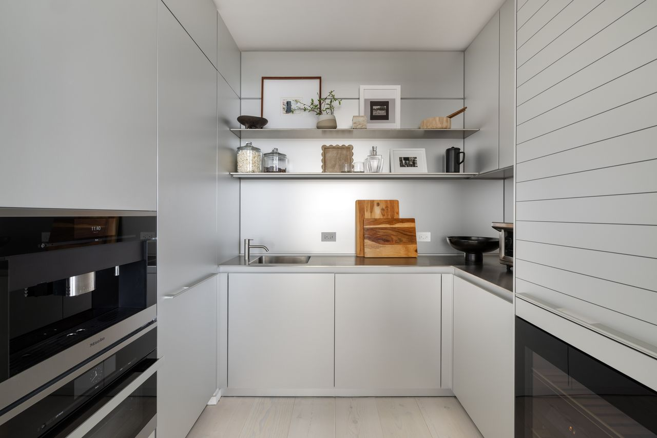 Tucked just beyond the main kitchen, a separate enclosed chef's kitchen provides additional prep space with its own freezer, wine refrigerator, steam oven, and secondary sink.