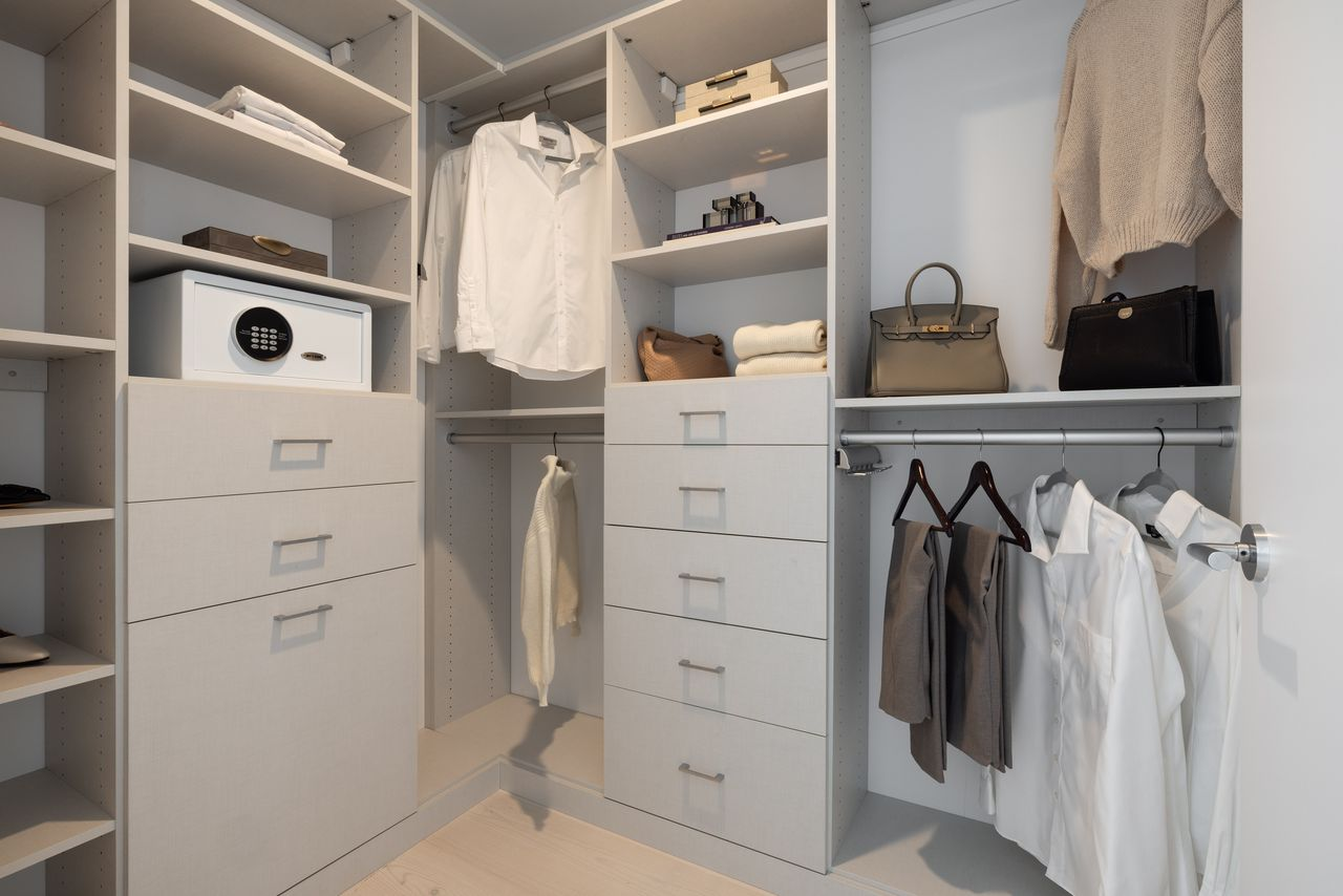 A custom walk-in closet with built-in shelving, drawers, and hanging storage.