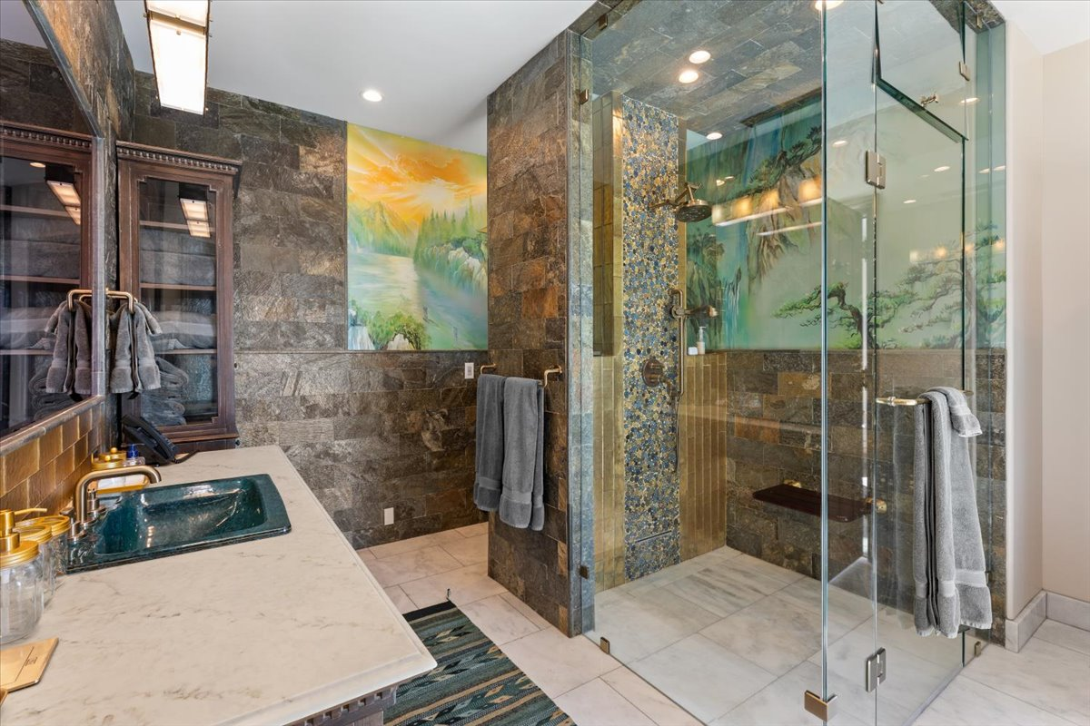 A spacious steam shower fitted with a bronze rain showerhead and matching fixtures.