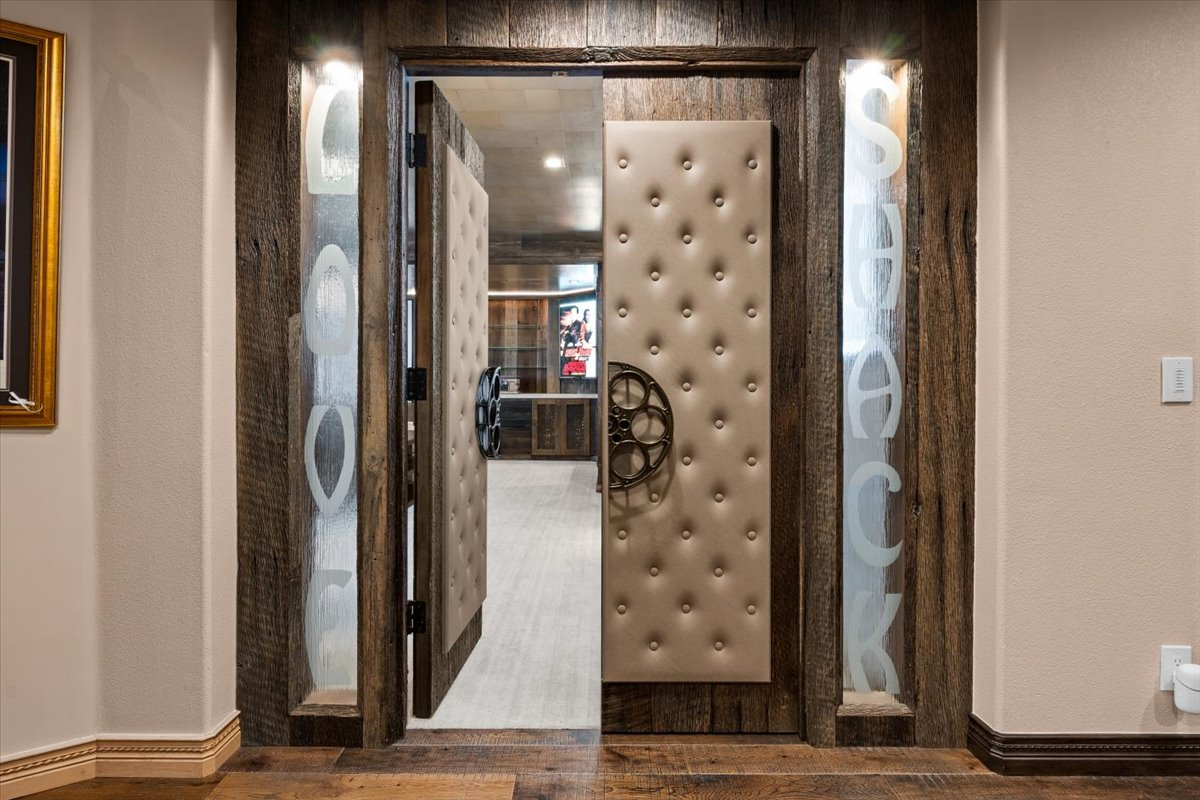 The private theater makes a memorable entrance with etched glass sidelights spelling out "Love Shack" and oversized film reel handles. 