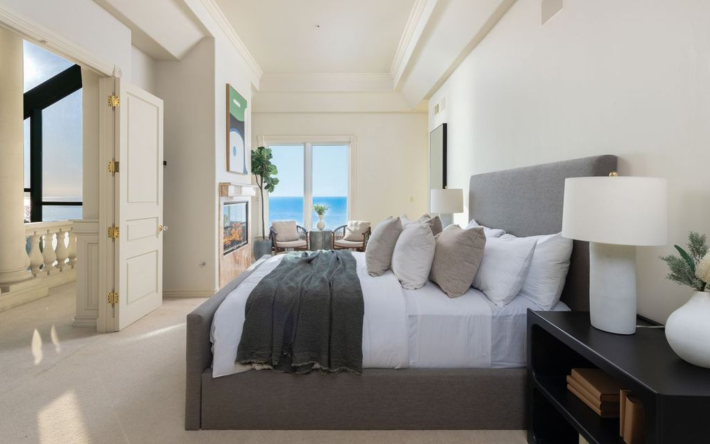 One guest suite enjoys views of the water, with a small sitting area placed near the fireplace on one side of the room, with the bed on the other.