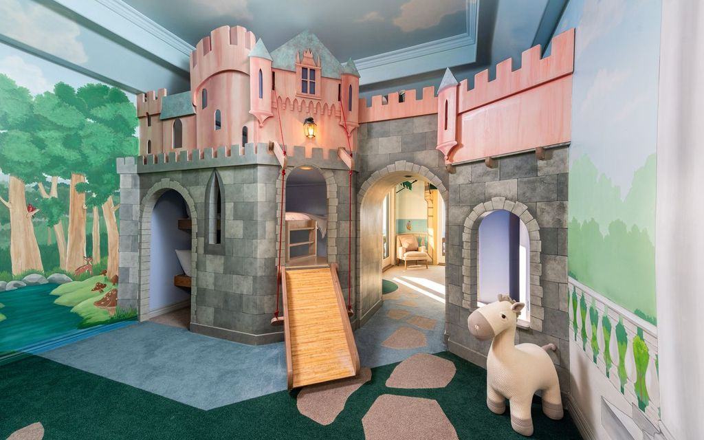 Bedroom that has been transformed into a whimsical play space centered around a custom castle-inspired bunk bed. 