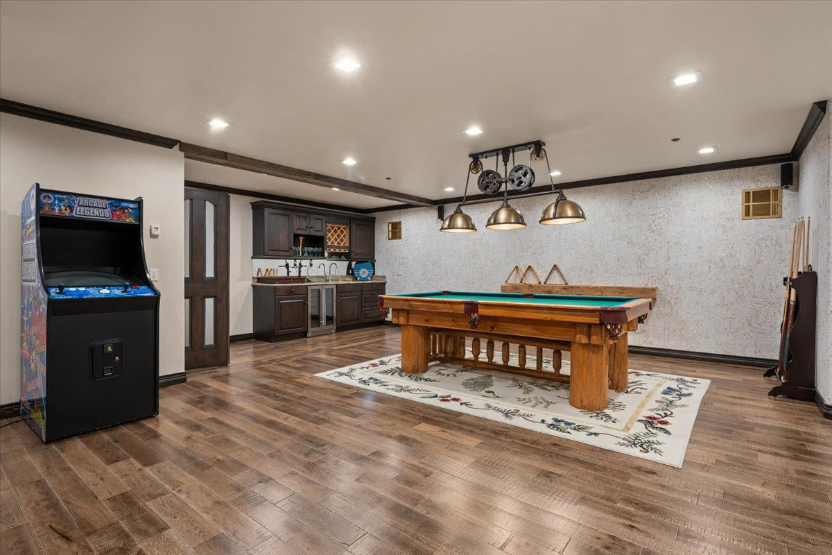 Another lower-level gathering space is centered around a log-style billiards table beneath industrial-inspired lighting. 