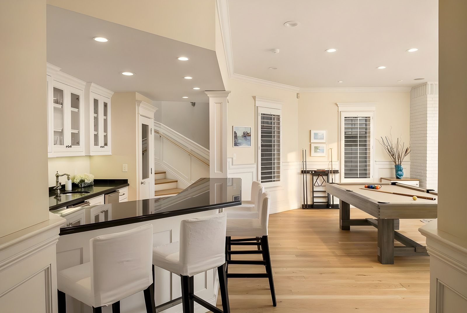 On the other side of the game area, a built-in wet bar offers a convenient place to prepare drinks without leaving the entertainment space. 