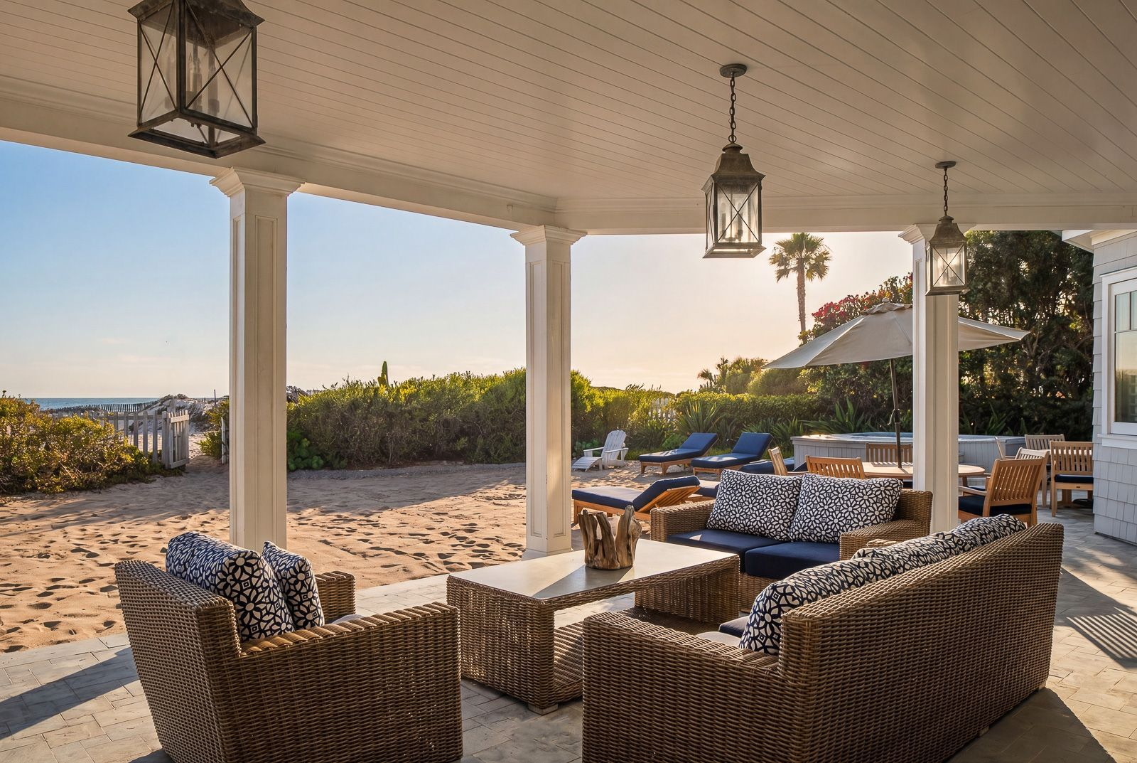 A spacious lounge beneath the covered terrace creates a natural extension of the home's living spaces, while multiple seating and dining areas are positioned to take in views of the water.