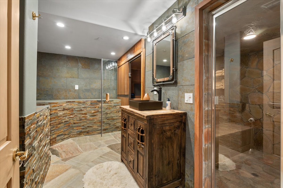A dedicated wellness wing with a cedar-lined sauna, steam room, and spa-inspired bath finished in natural stone.