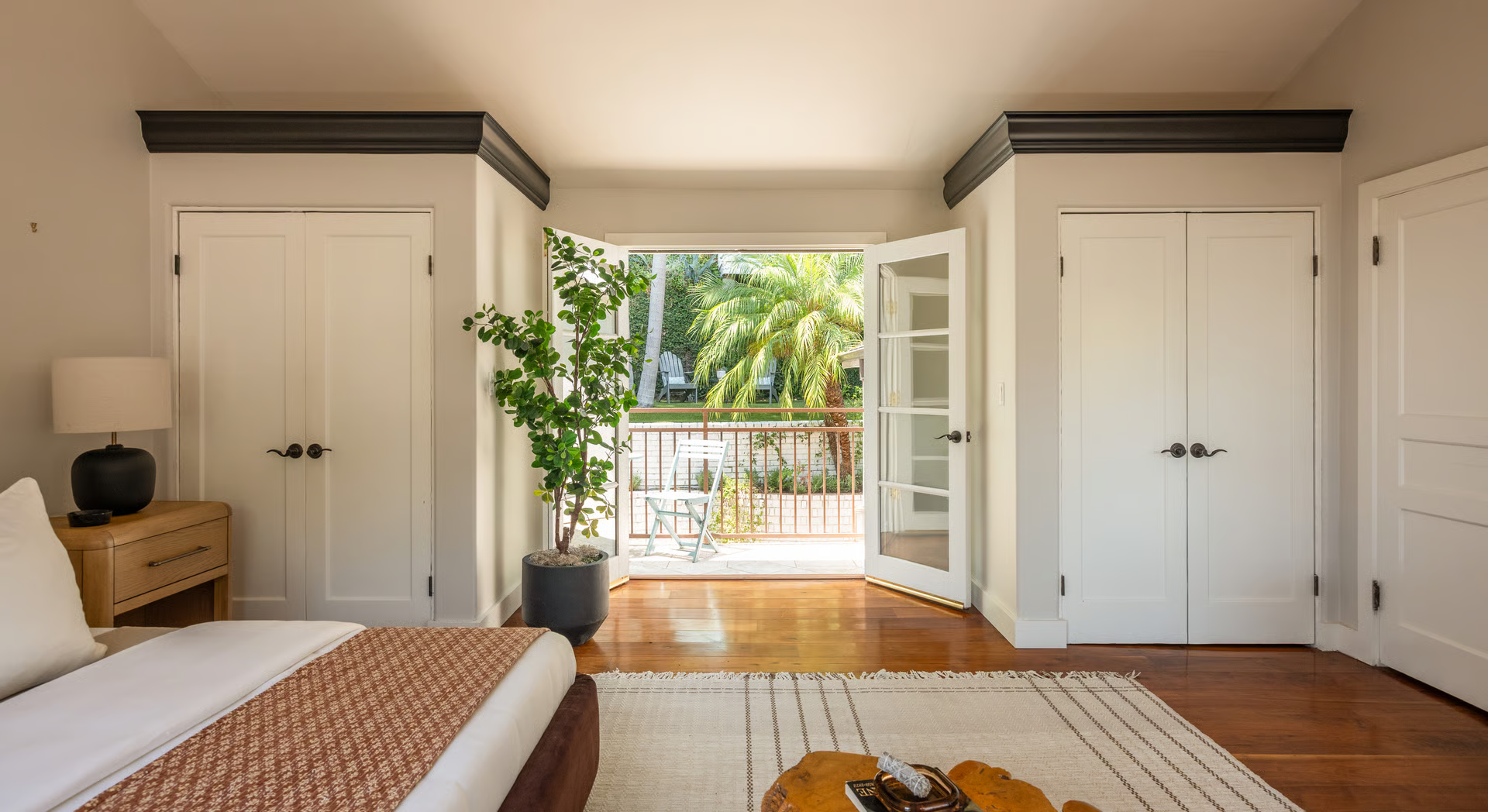 French doors swings open to a large private balcony with a bistro table overlooking the backyard.