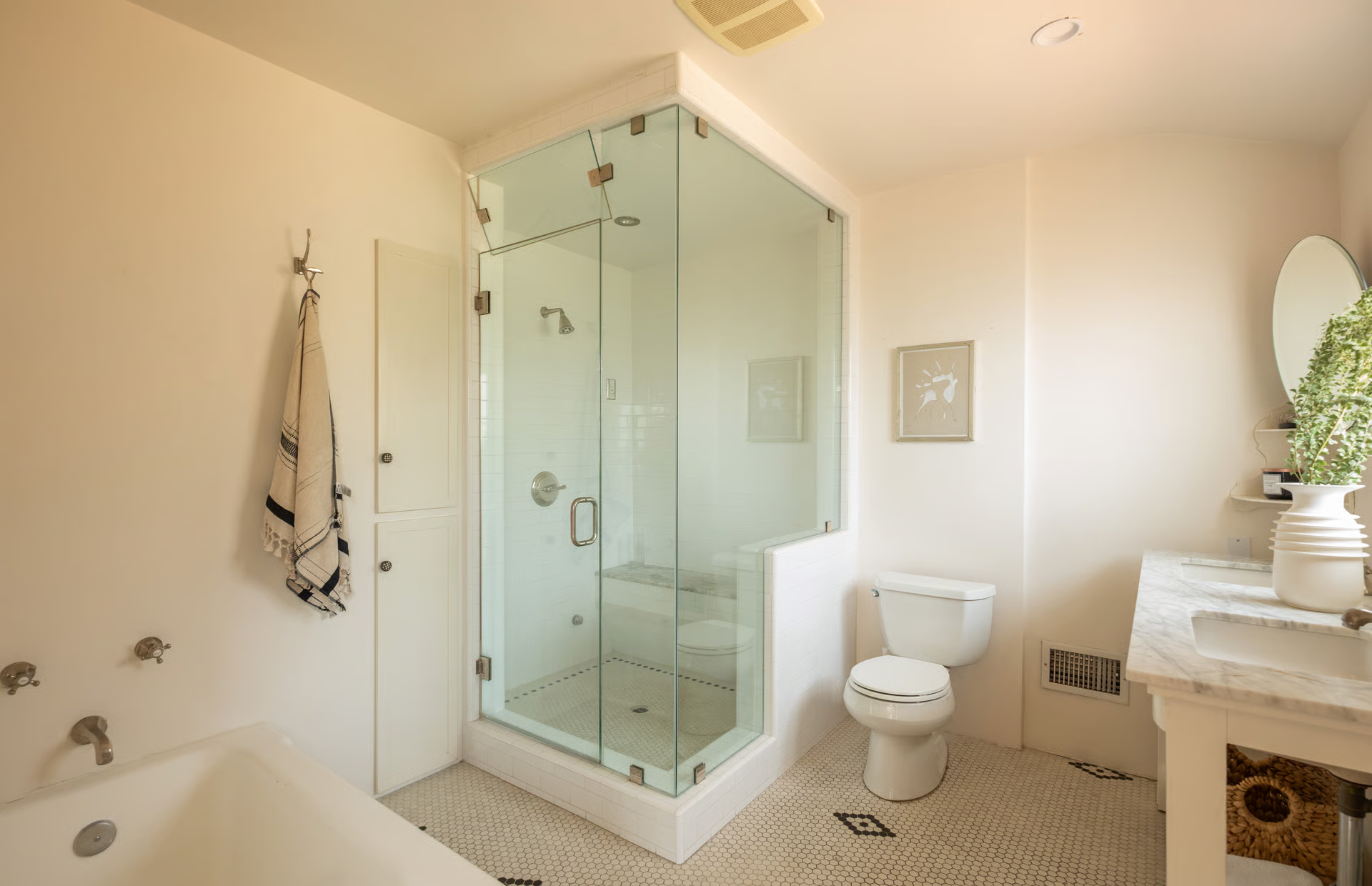 A deep soaking tub sits opposite a spacious glass-enclosed shower, while a dual vanity stretches along one wall.