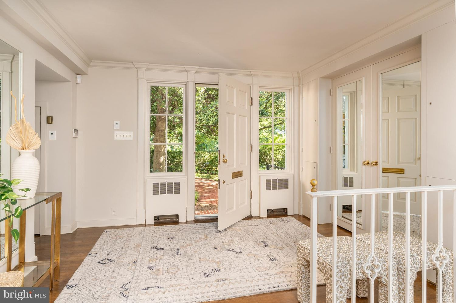 Stepping through the front door, the home opens into a bright foyer framed by tall windows that pull views of the front yard greenery directly inside.