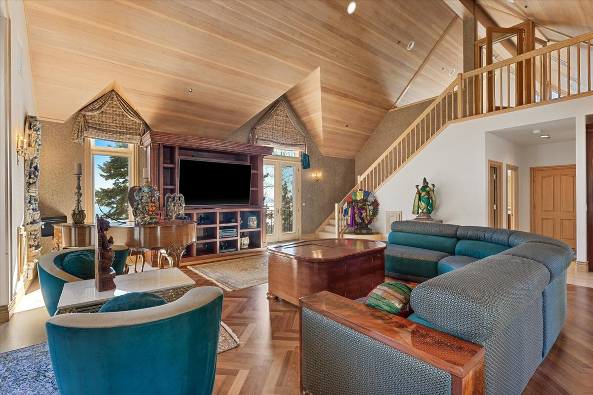The room features a pitched ceiling designed for acoustics, custom built-ins, a wet bar, and a private bathroom.