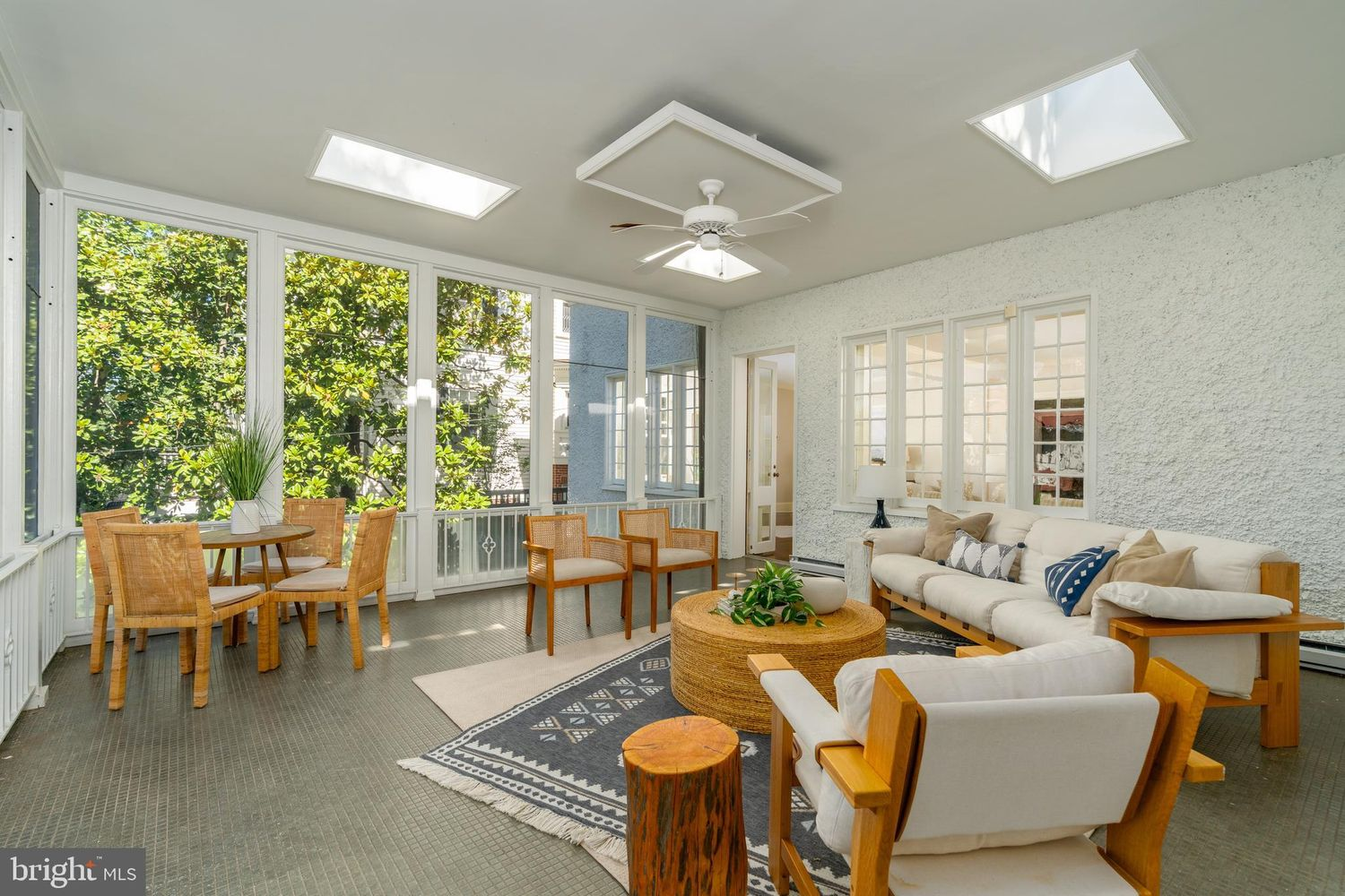 A bright sunroom where nearly every wall is lined with oversized windows, while skylights overhead draw in even more natural light.