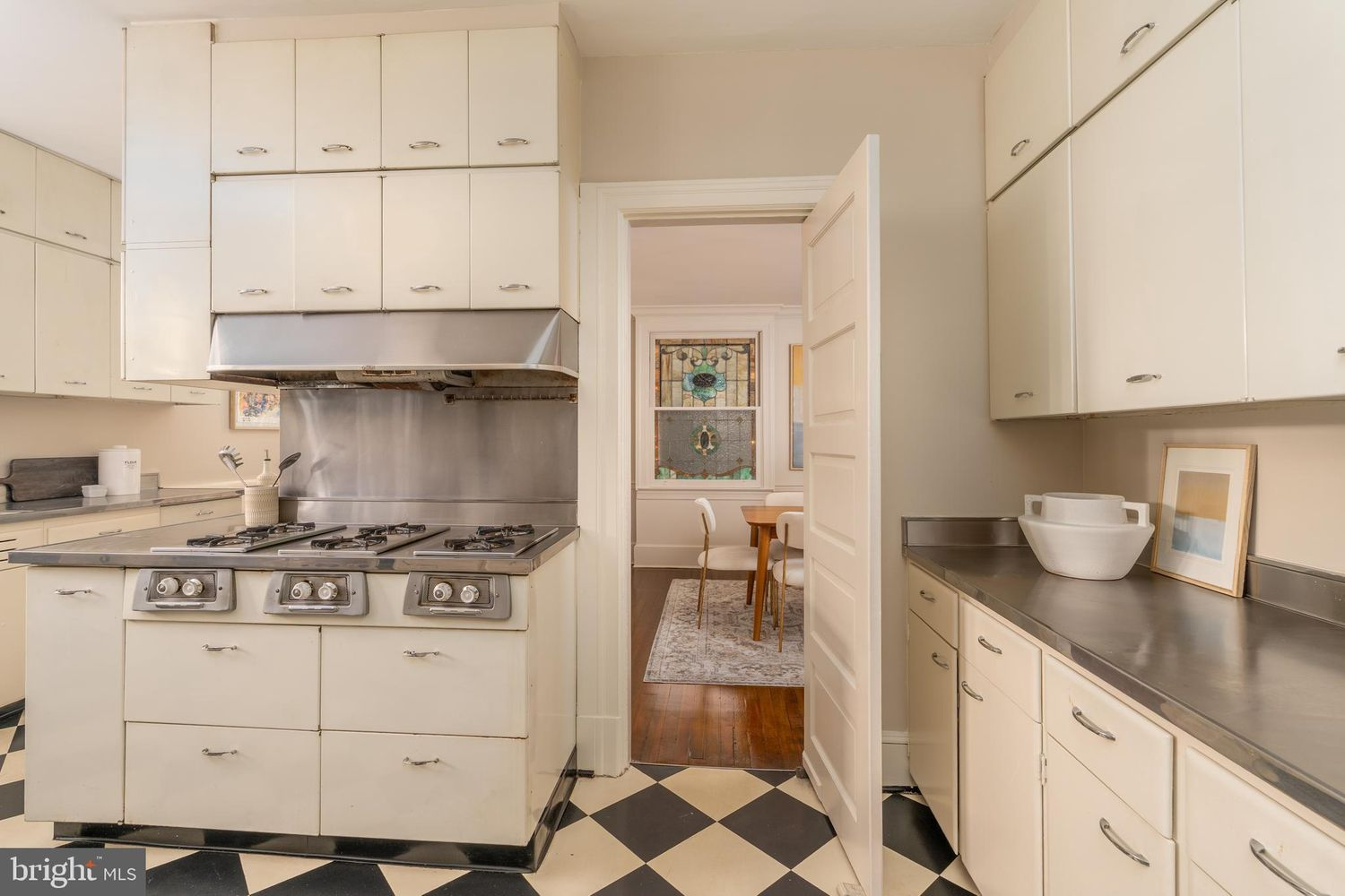On the opposite end, the kitchen centers around a substantial vintage-style range framed by the room's stainless steel surfaces and more built-in storage.