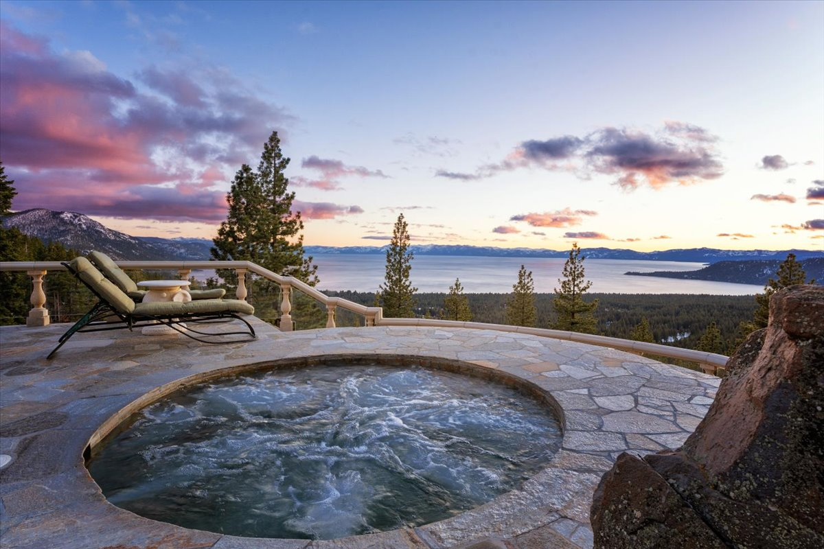 At the edge of the patio, a 10-person hot tub sits next to a couple of lounge chairs, creating a front-row seat to sunsets over the lake.