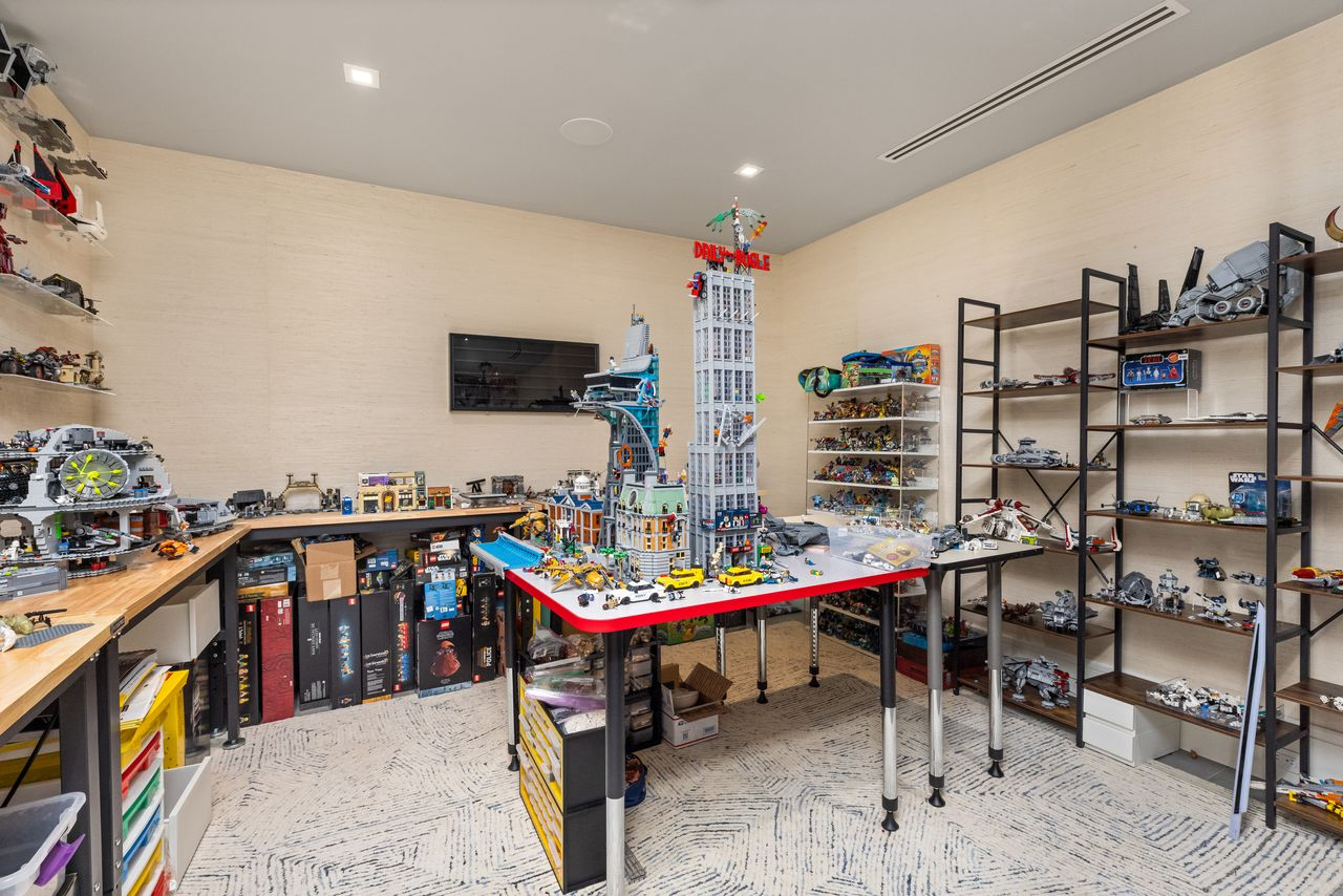 Designed with custom workstations wrapping the perimeter, open display shelving, and generous floor space at the center.