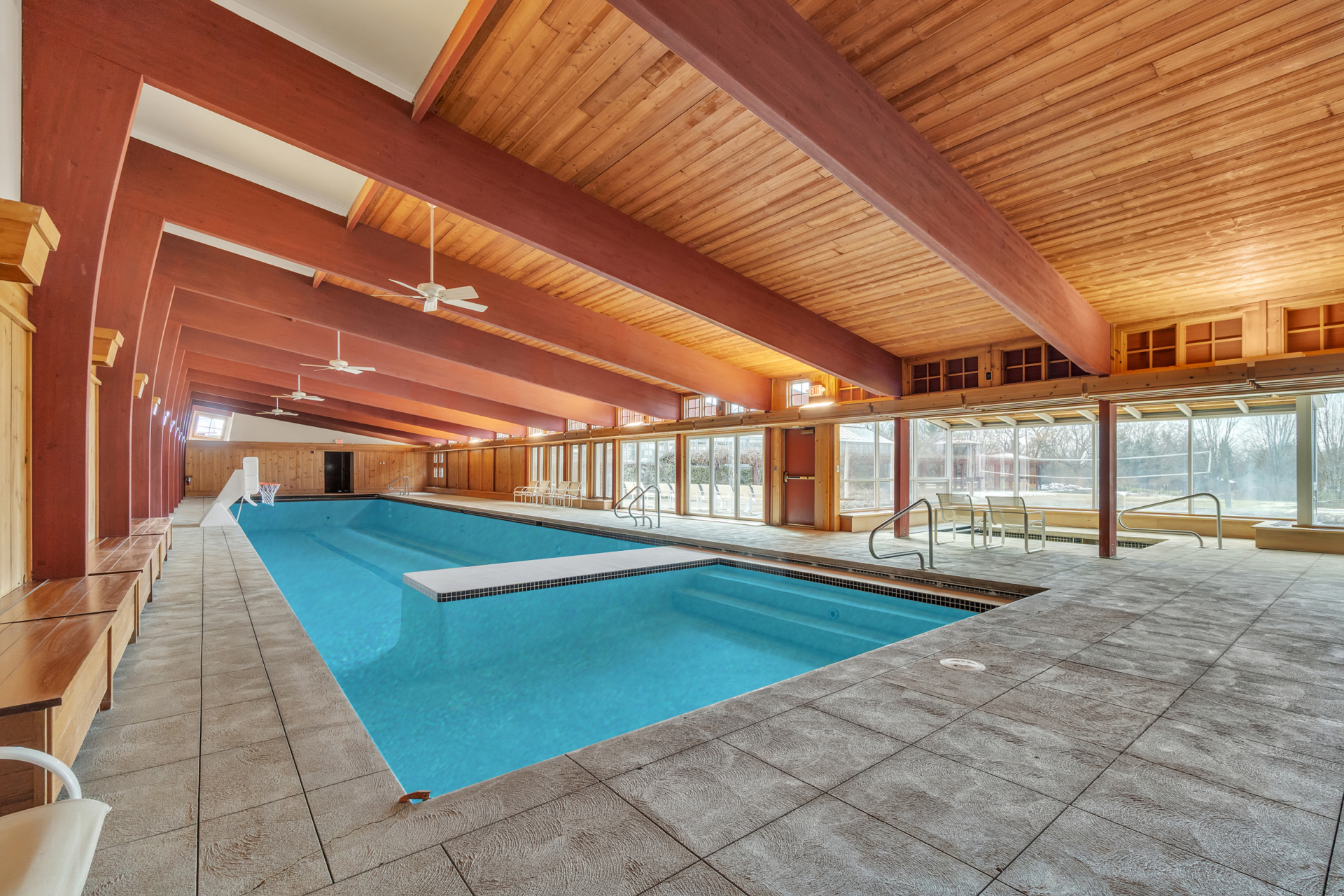 A dedicated pool pavilion centers around a full-length indoor swimming pool and spa alongside nearly an entire wall of glass that line one side of the room.