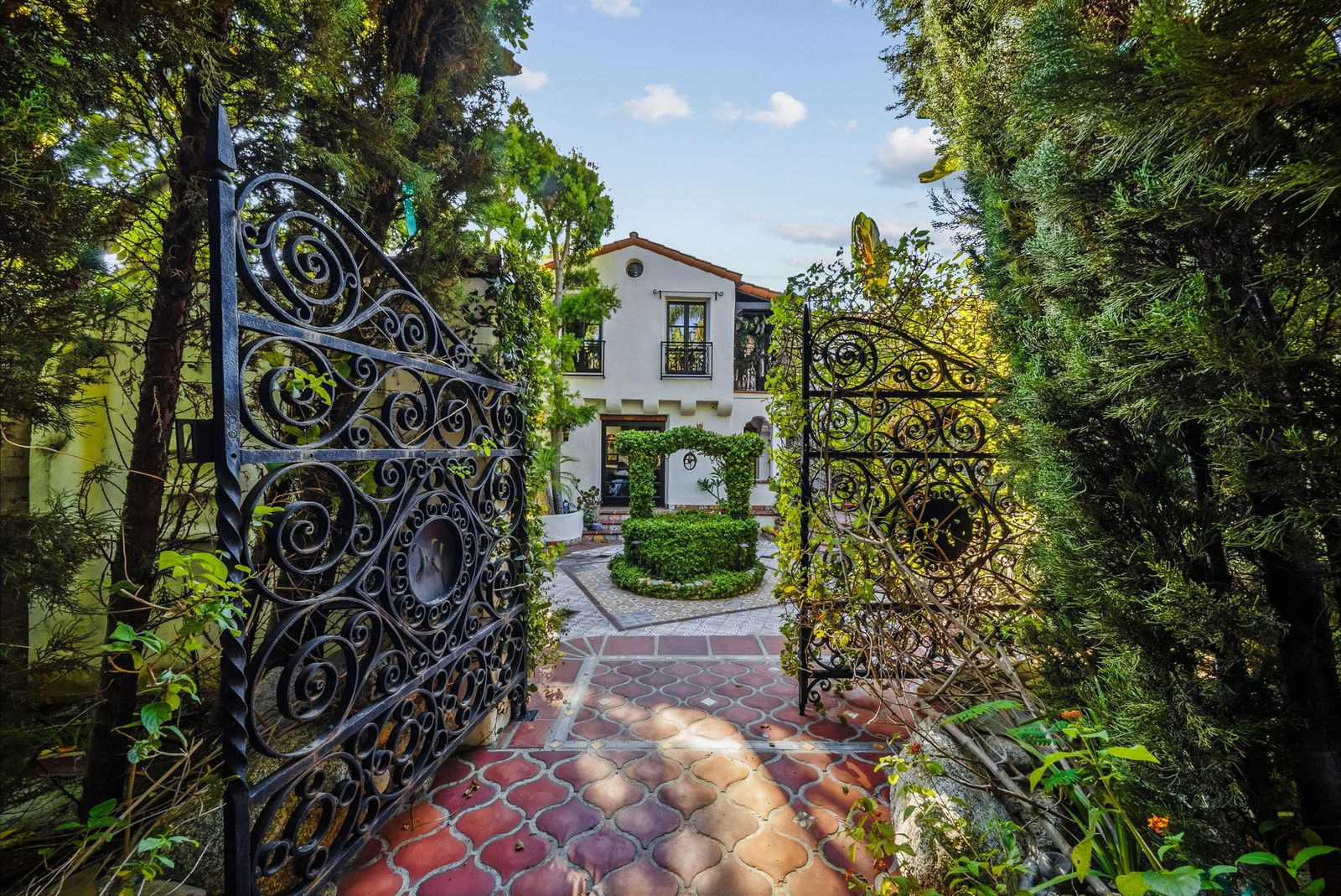 Passing through wrought-iron gates, David Ayer's home opens into a rebuilt Spanish-style courtyard centered around a garden.